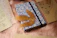 Close-up of a pastel-toned notebook adorned with delicate leaf patterns on a wooden desk.
