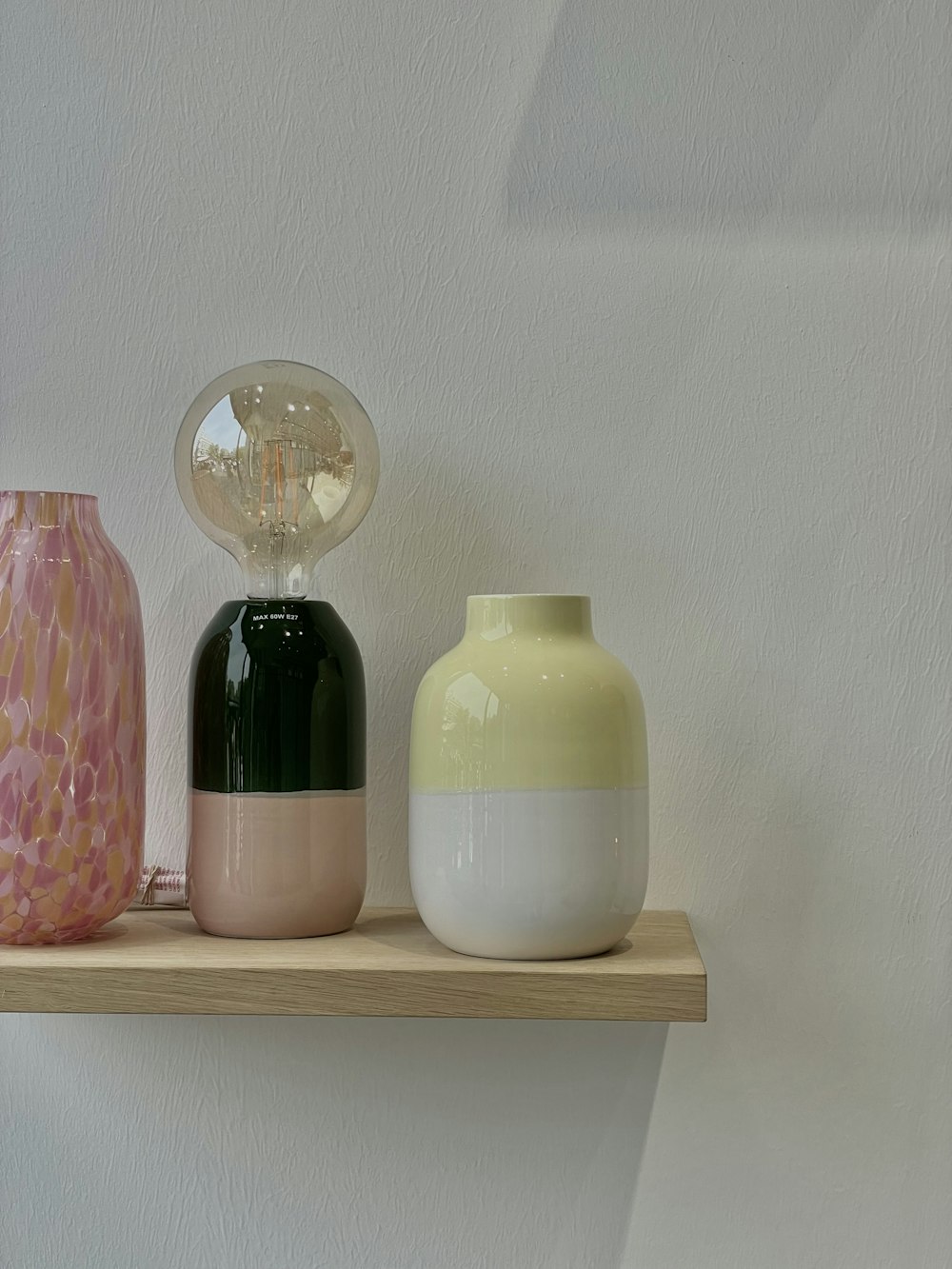 three vases sitting on a shelf next to each other