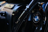 A close-up view of a BMW motorcycle engine. The image prominently features the BMW logo and an emblem indicating an 1800cc engine capacity. The surface has a shiny, metallic black finish with reflective accents.