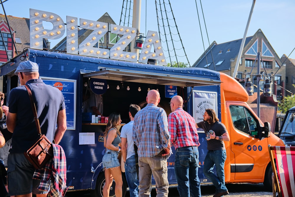 a group of people standing outside of a food truck