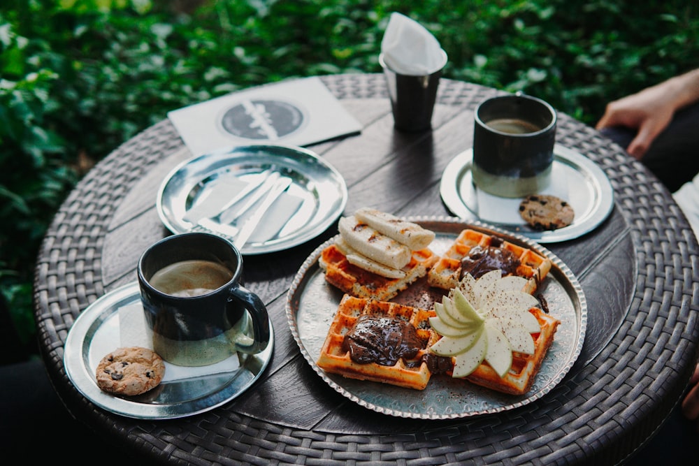 a plate of waffles and a cup of coffee on a table