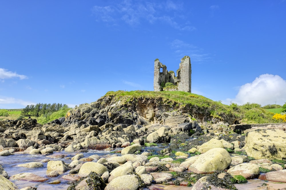 a castle sitting on top of a lush green hillside