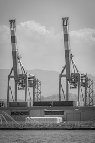 Monochrome image of a sleek shipping container being loaded at a French port, symbolizing international distribution.