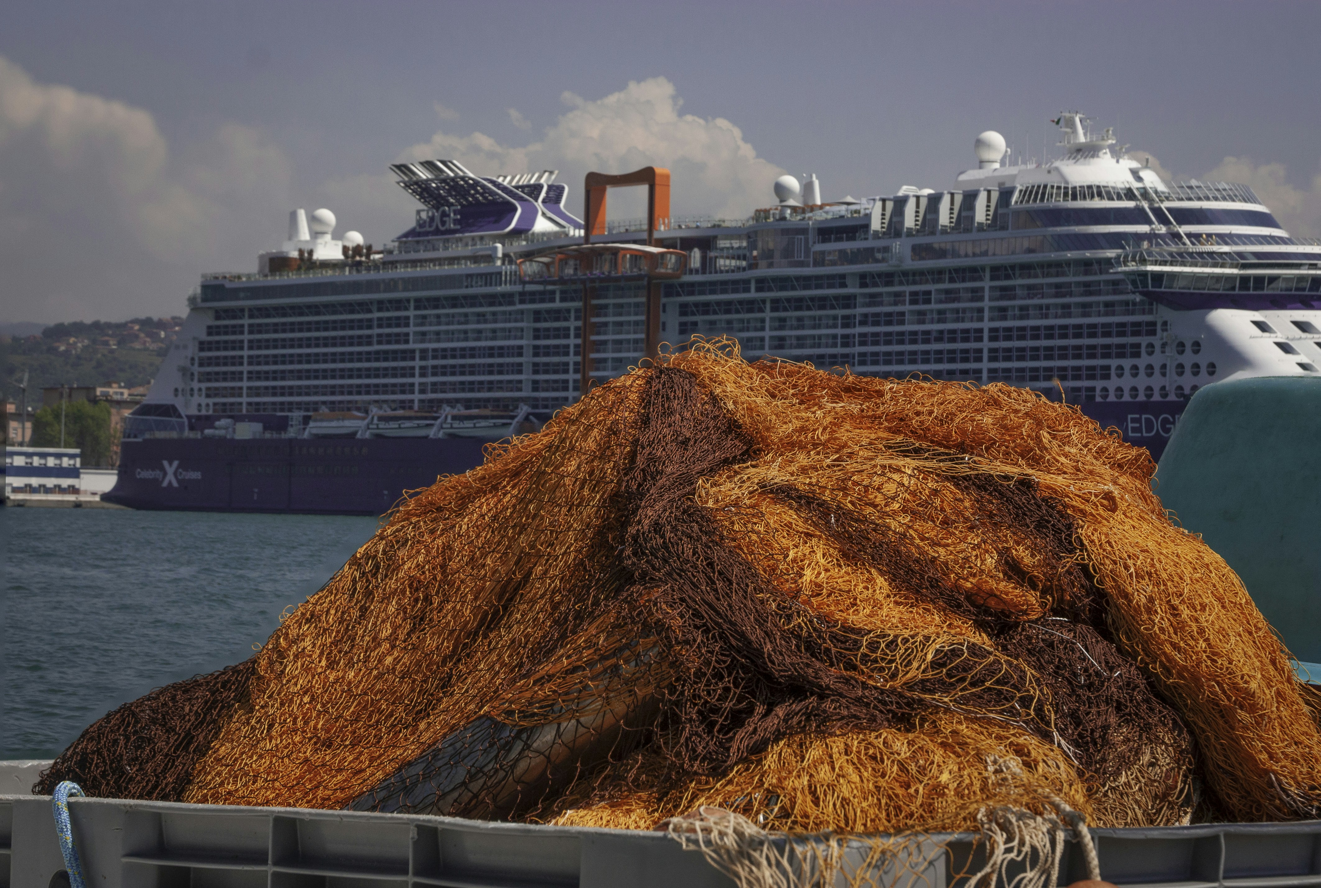 a large cruise ship in the background with a pile of hay in the foreground