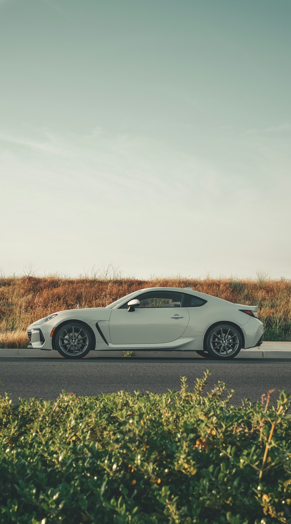 a white sports car parked on the side of the road