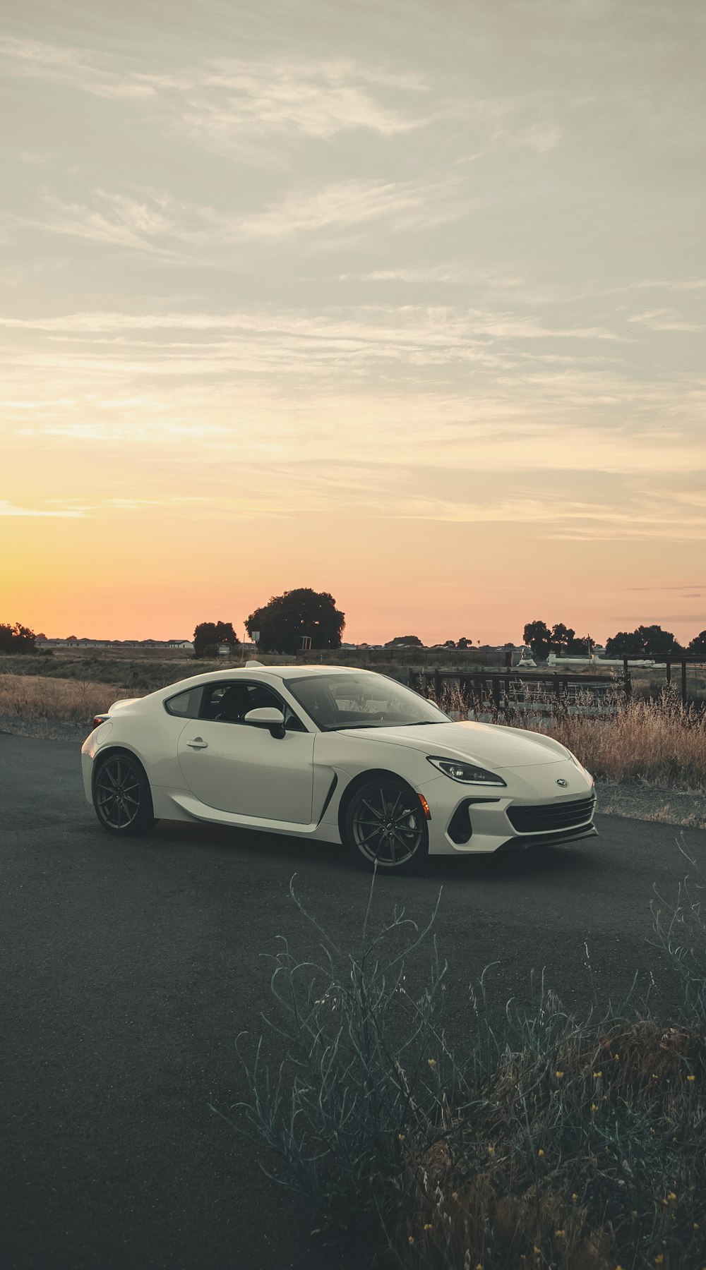 a white sports car parked on the side of the road