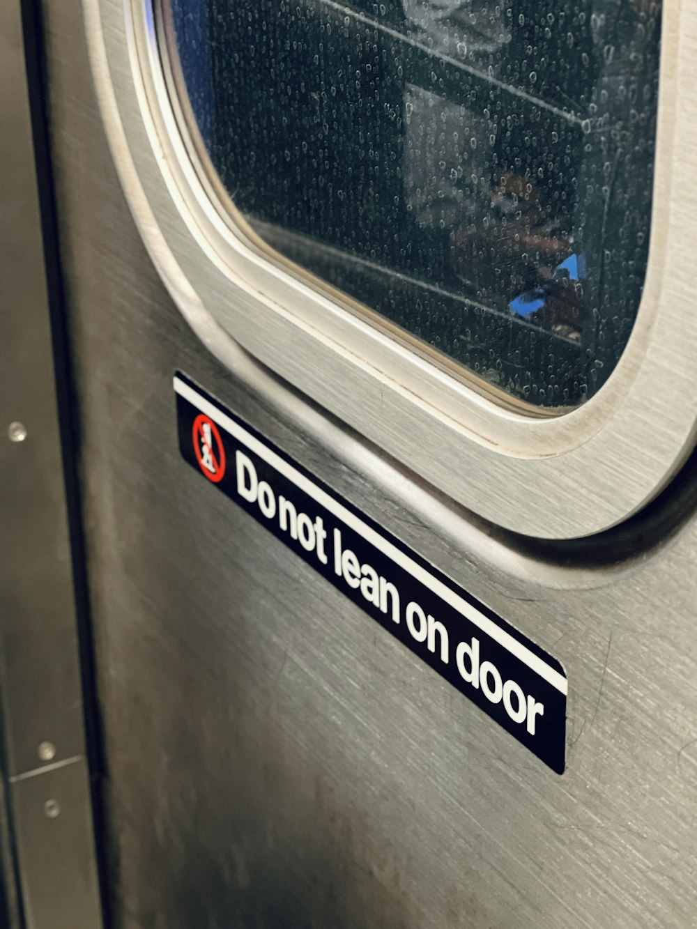 a door with a sticker that says don't lean on door