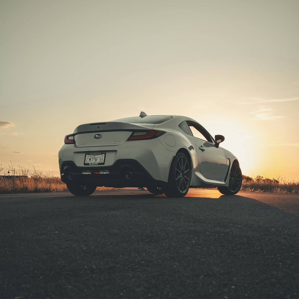 a white sports car parked on the side of the road