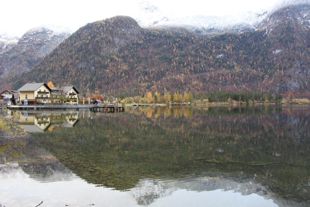 a house on a lake surrounded by mountains