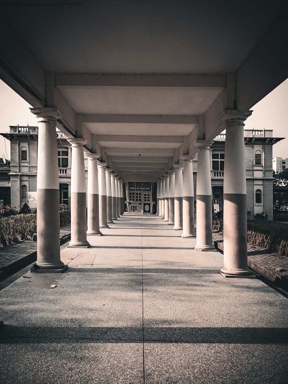 a row of white pillars sitting under a bridge