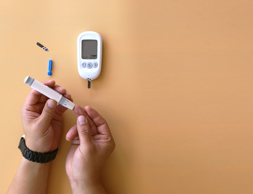 a person holding a thermometer next to an electronic device