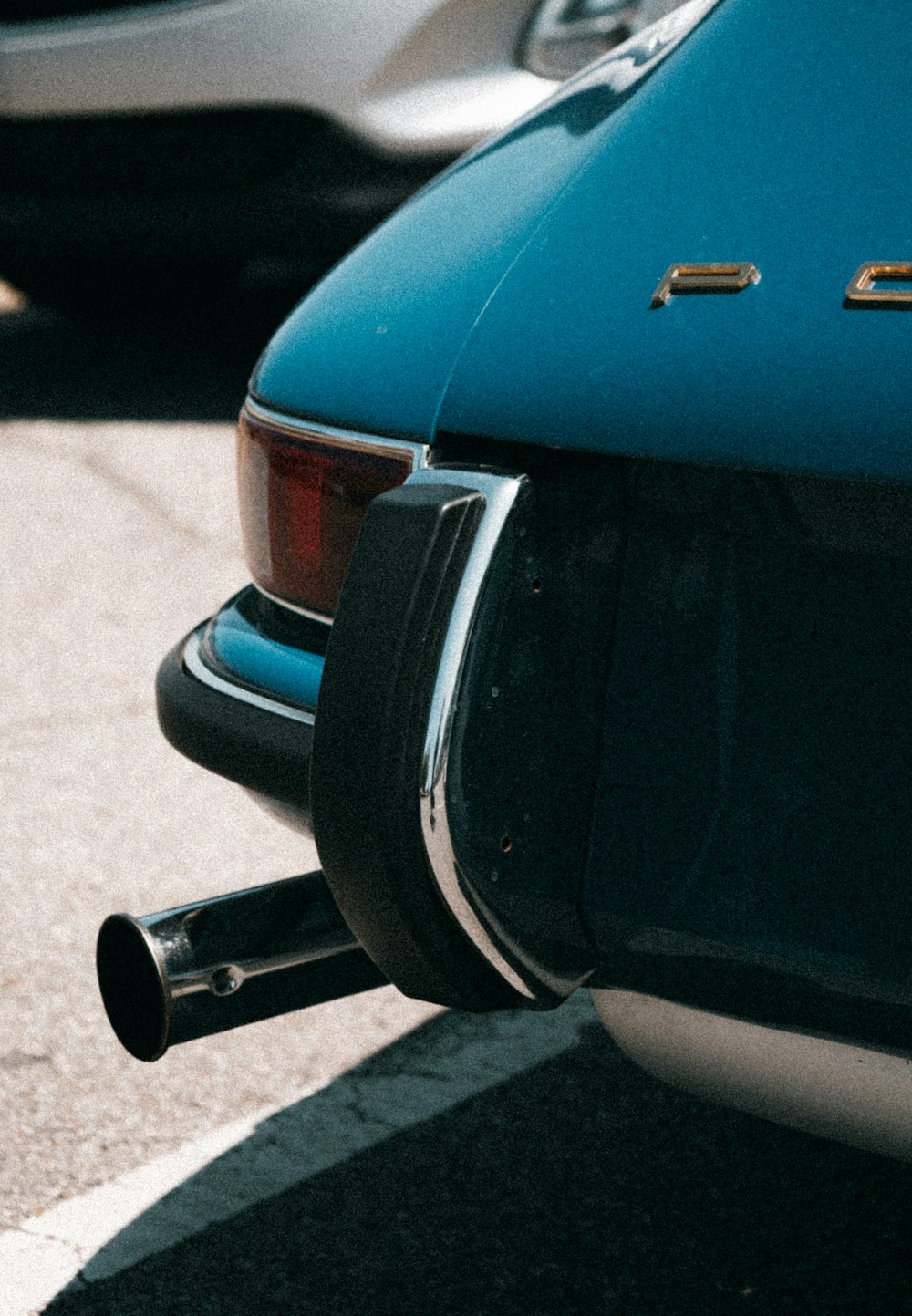 a blue car parked next to a parking meter