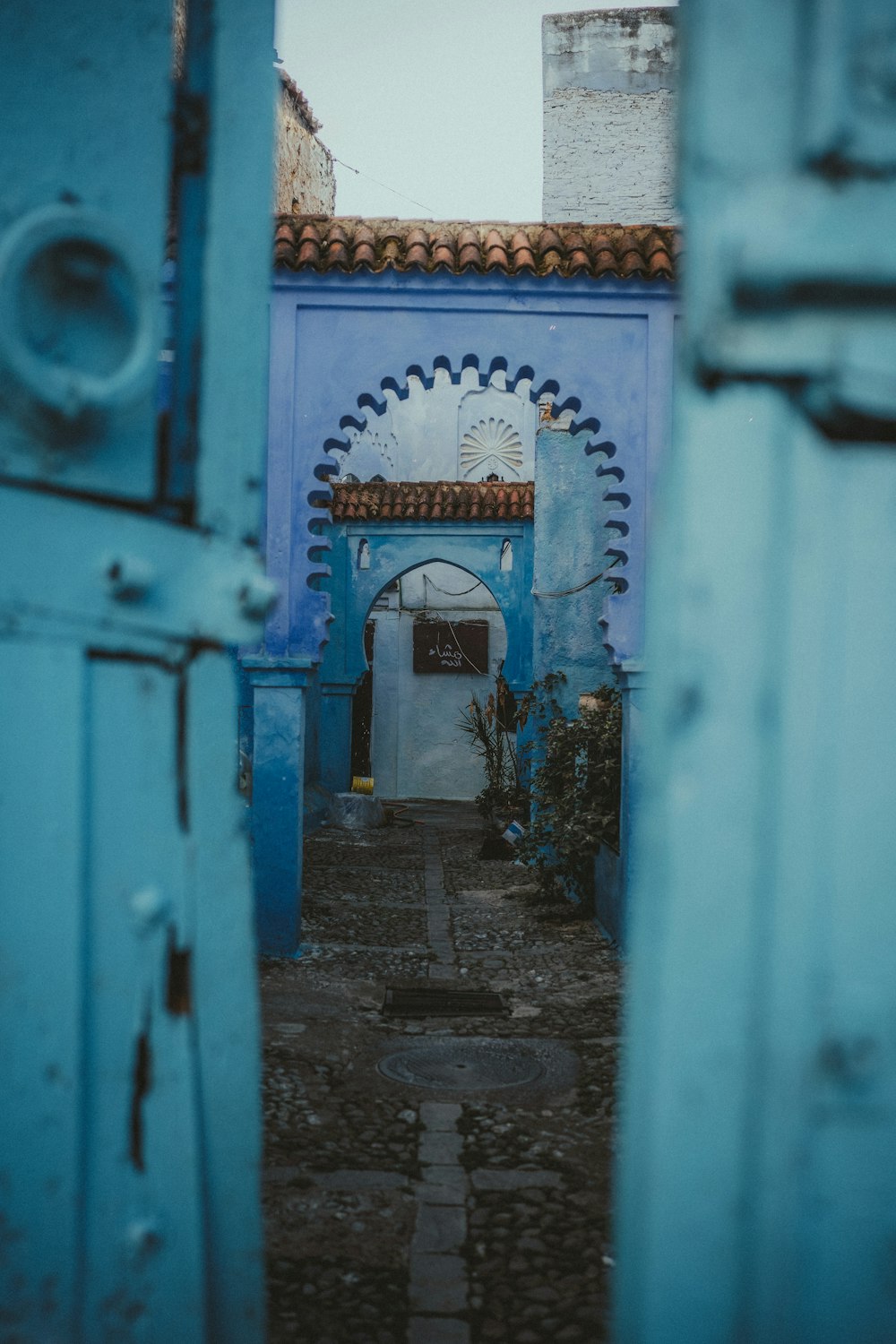 a blue building with a doorway leading to another building