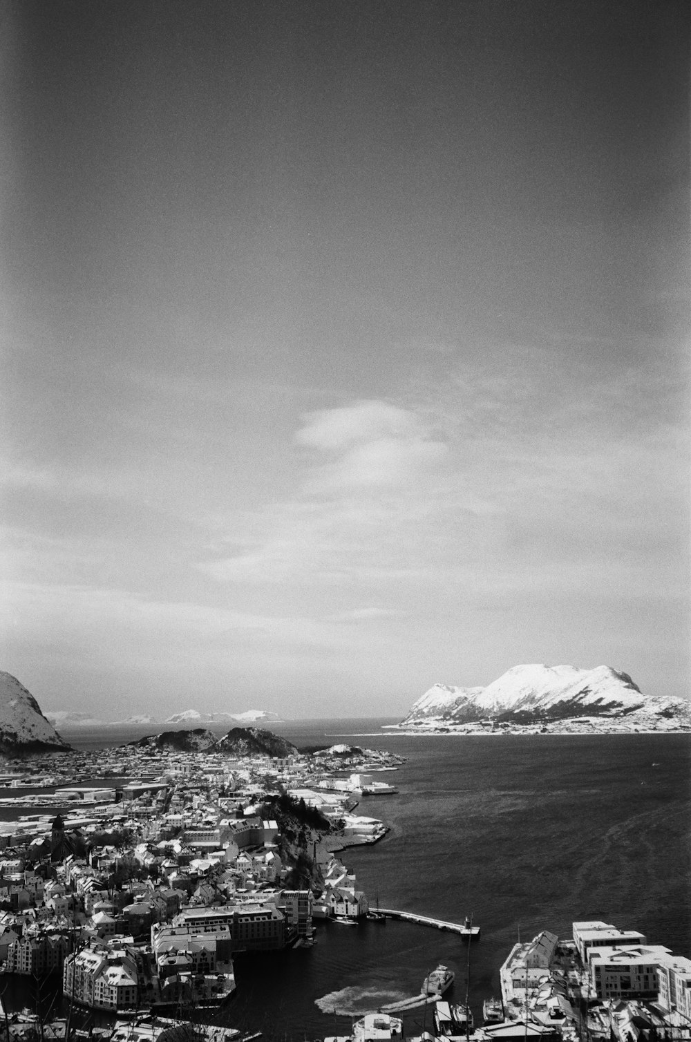 a black and white photo of a city with mountains in the background