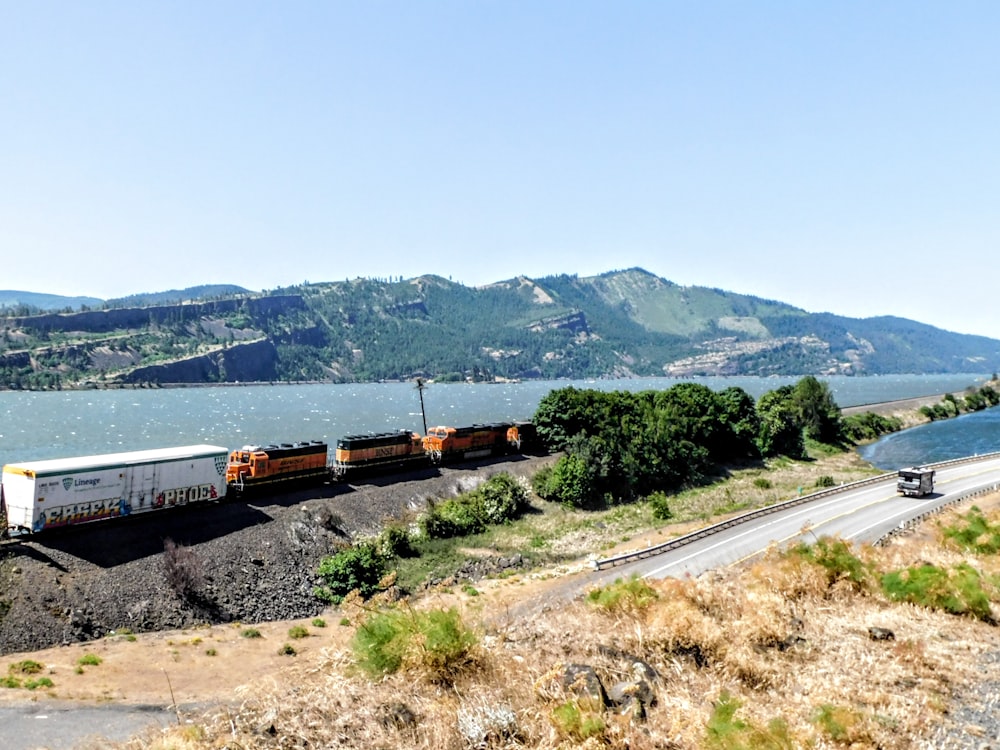 a train traveling down tracks next to a body of water