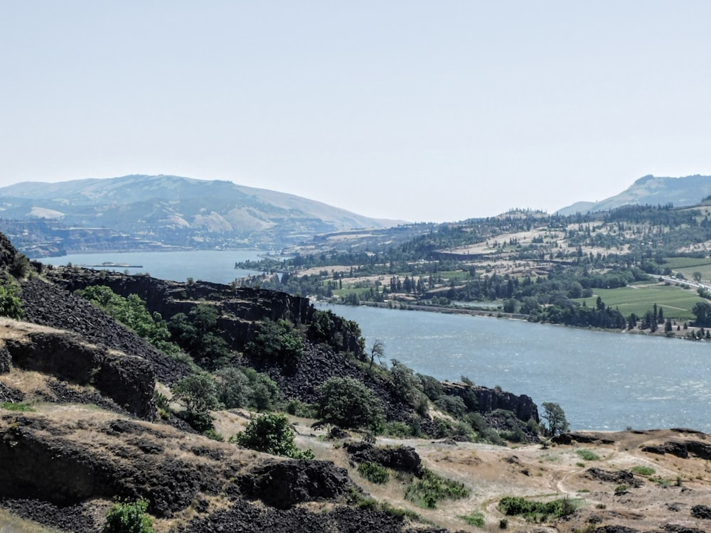 a view of a river and mountains from a hill