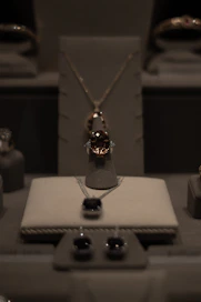 Elegant display of golden and beige jewelry pieces arranged on a soft beige background with subtle golden reflections.