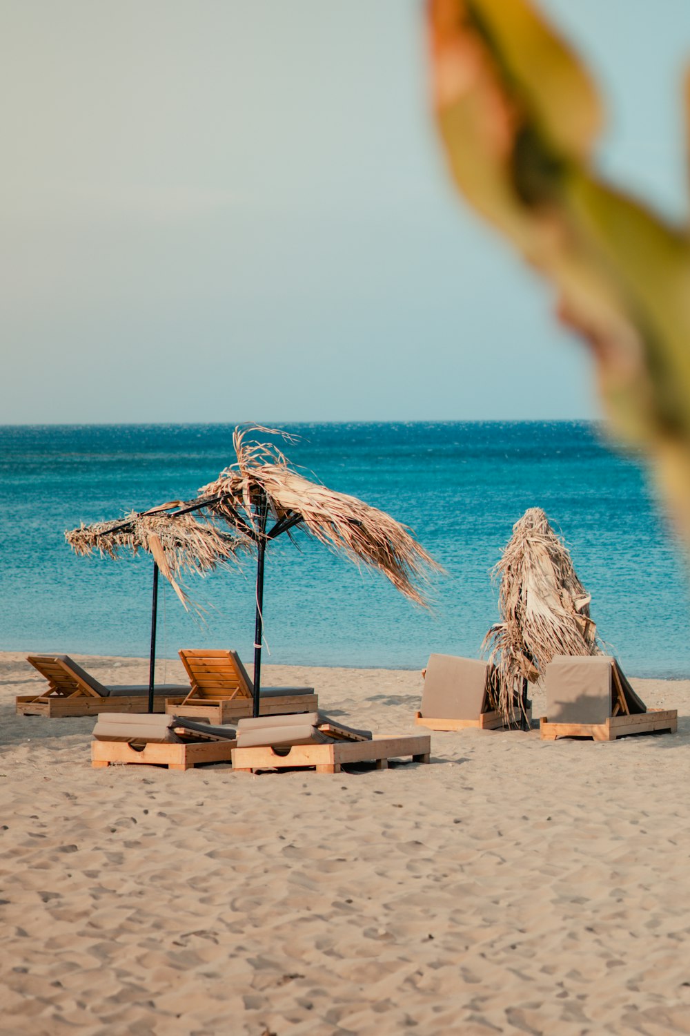 a beach with lounge chairs and umbrellas on the sand