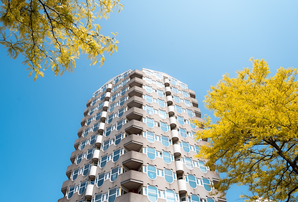 a tall building with lots of windows next to trees