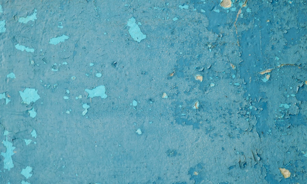 a blue wall with peeling paint on it