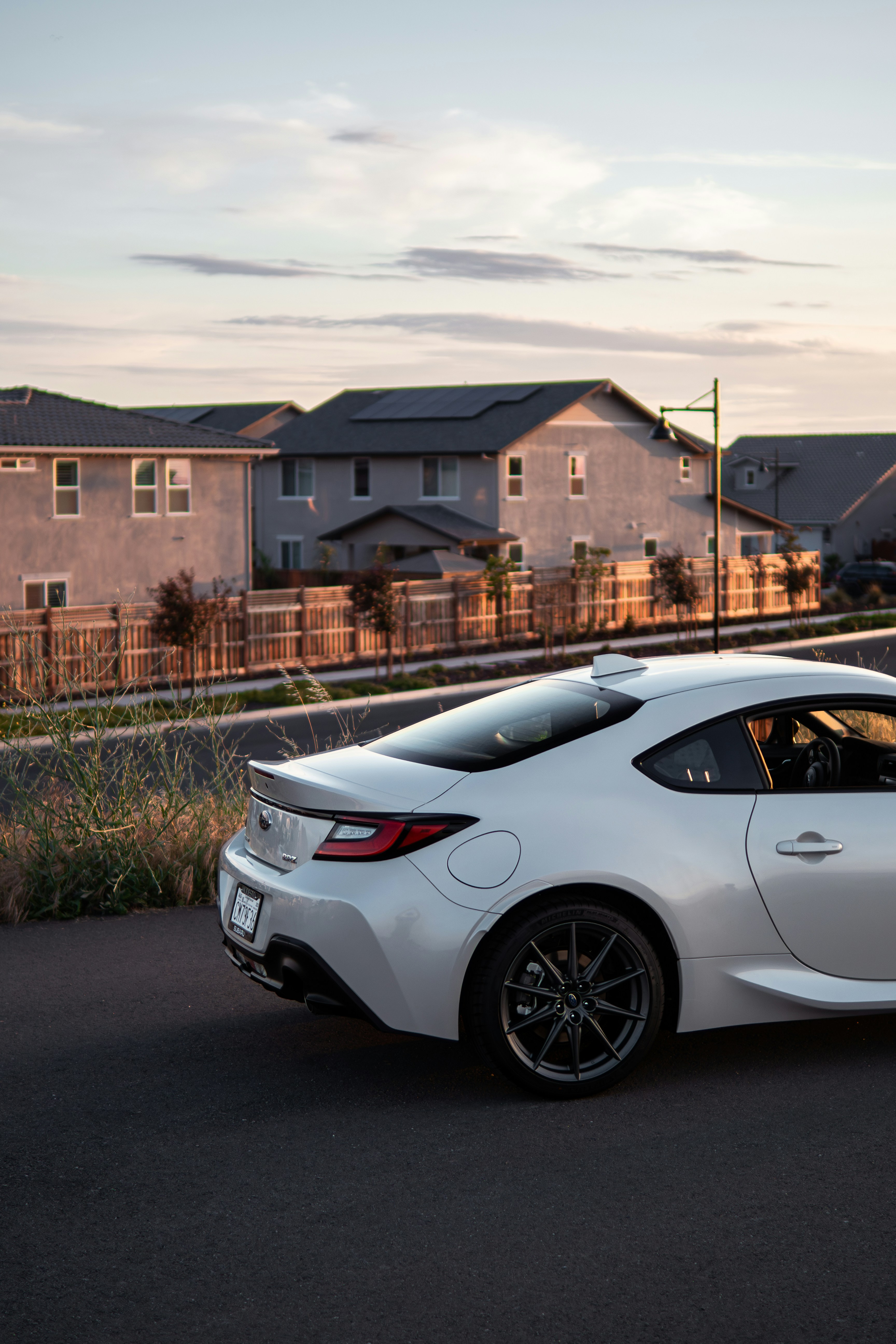 a white sports car parked on the side of the road