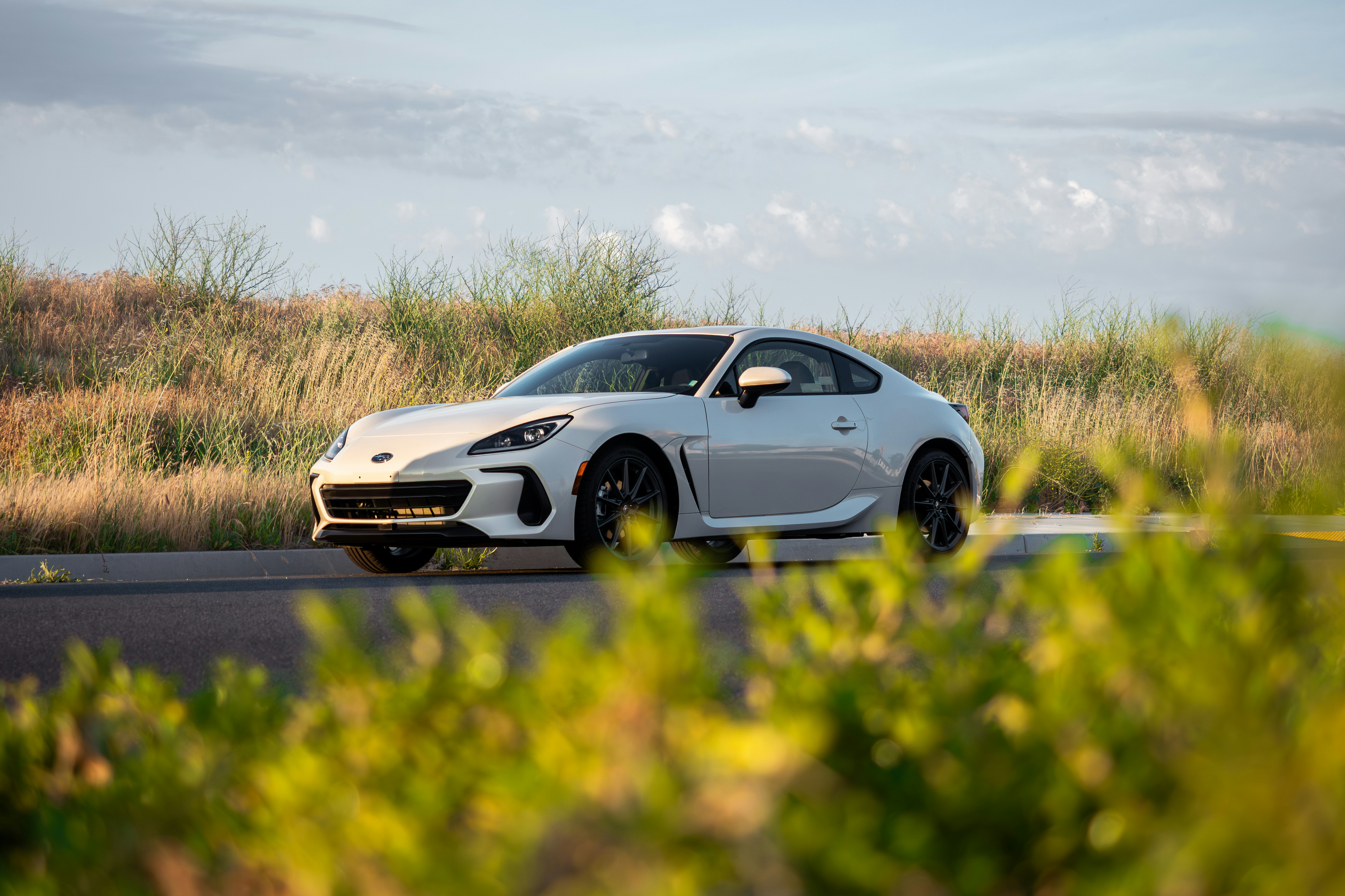 a white sports car parked on the side of the road