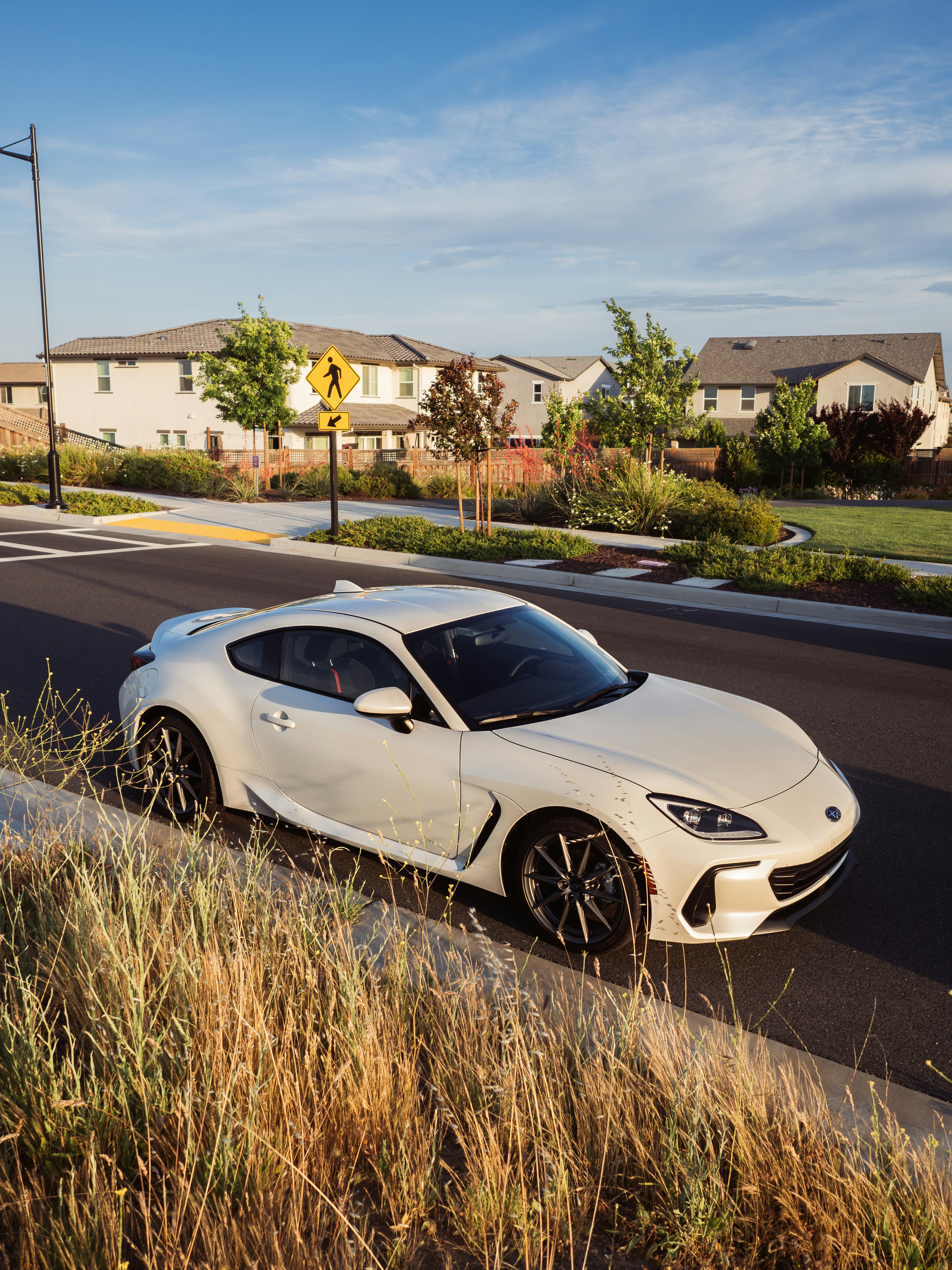 a white sports car parked on the side of the road