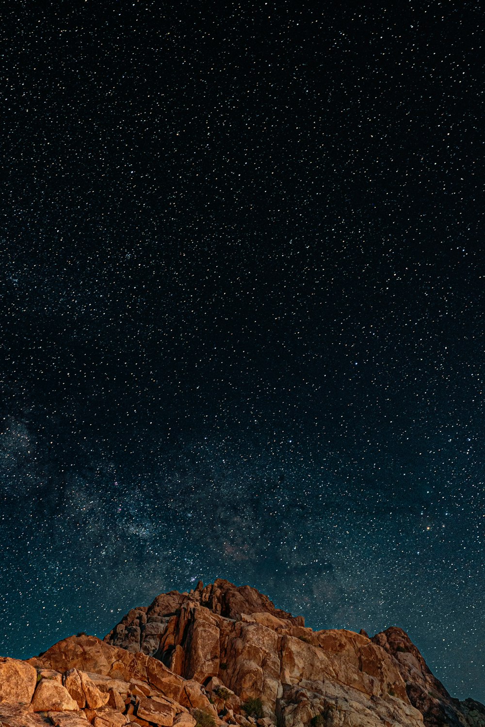 the night sky over a rocky mountain range