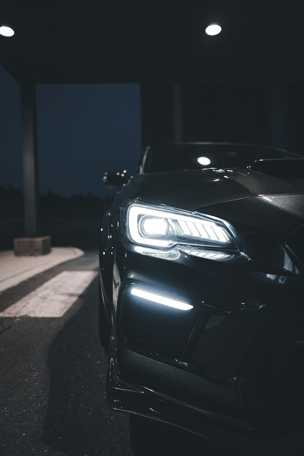 a black car parked in a parking lot at night