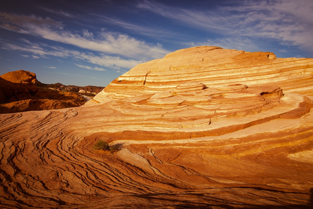 a large rock formation in the desert under a blue sky