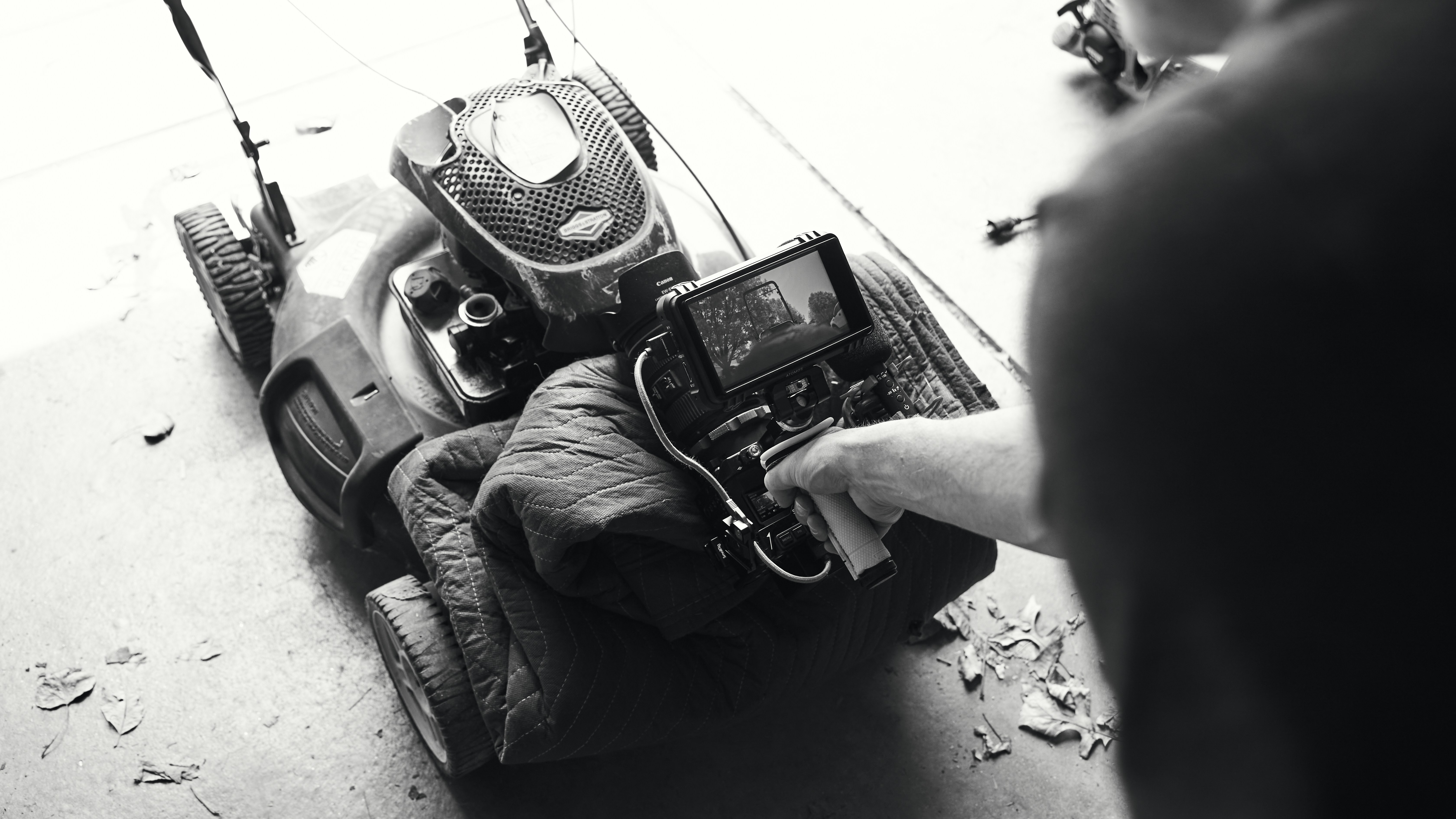 a black and white photo of a person holding a camera