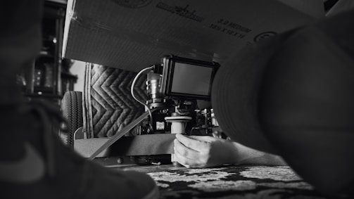 a black and white photo of a person using a camera