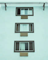 Apartment building facade showing multiple windows fitted with discreet air vents
