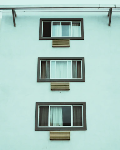 Apartment building facade showing multiple windows fitted with discreet air vents.
