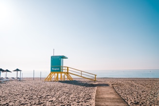a lifeguard stand on the beach next to the ocean