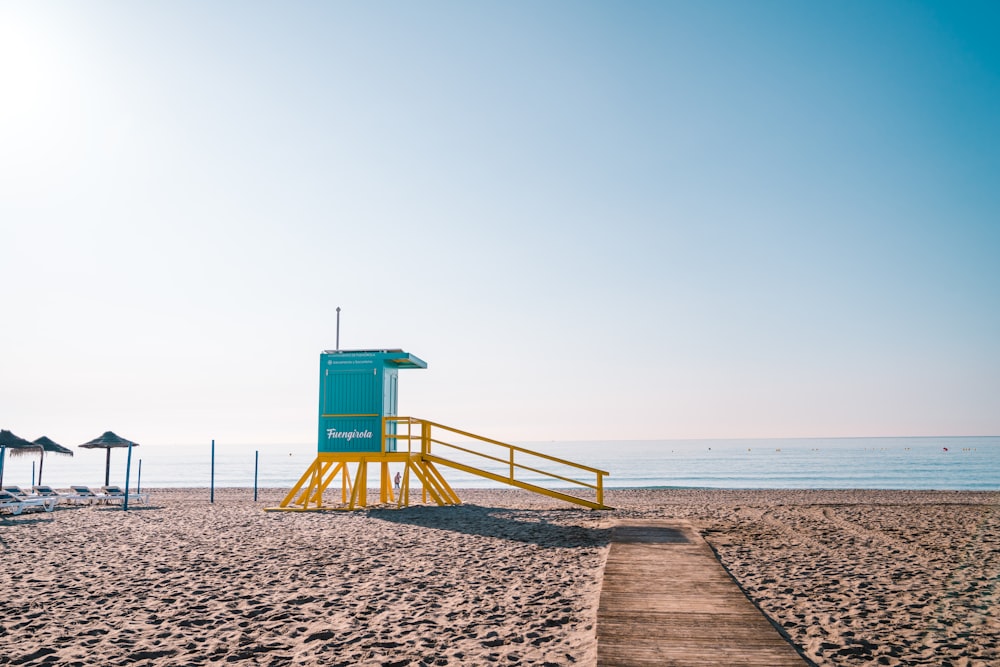 a lifeguard stand on the beach next to the ocean