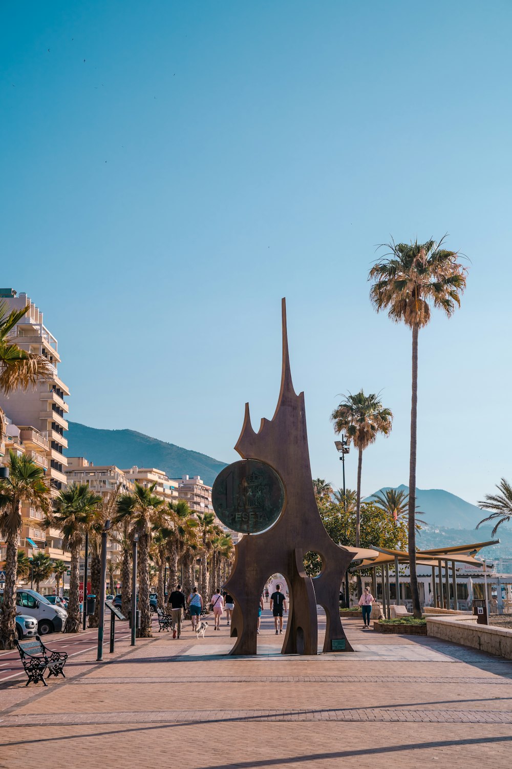 a statue of a dog in a plaza with palm trees