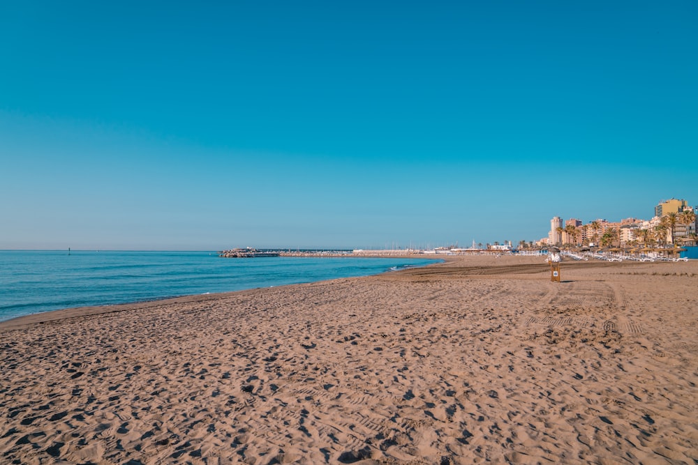 a sandy beach next to a body of water