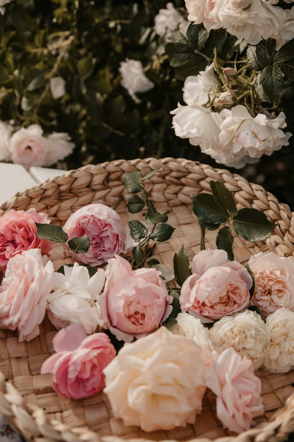 a wicker basket filled with pink and white flowers