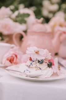 Close-up of a beautifully styled dessert with delicate edible flowers on a white plate.