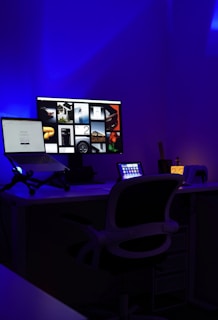 a computer desk with two monitors and a laptop