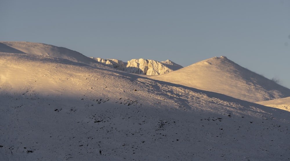 a mountain covered in snow with a sky background