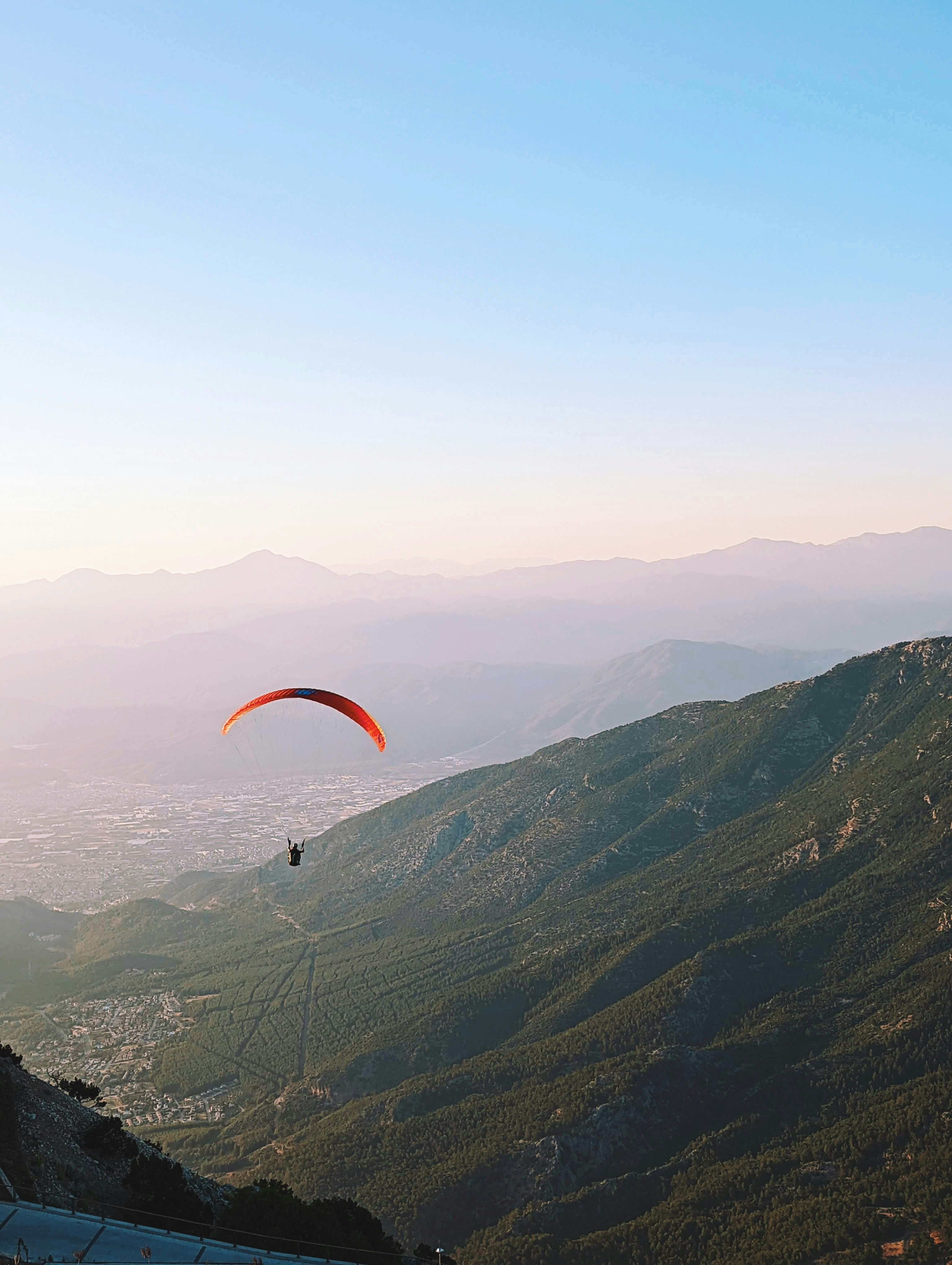 a paraglider is flying over a mountain range