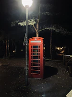 The dark red telephone booth illuminated softly at night, symbolizing our name.