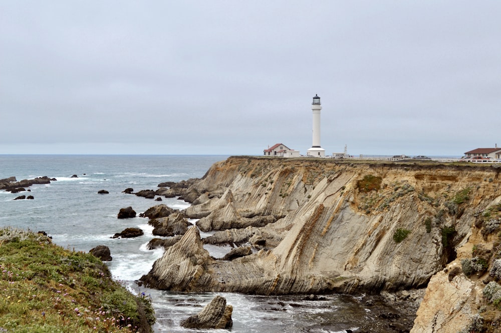 a light house on a cliff overlooking the ocean