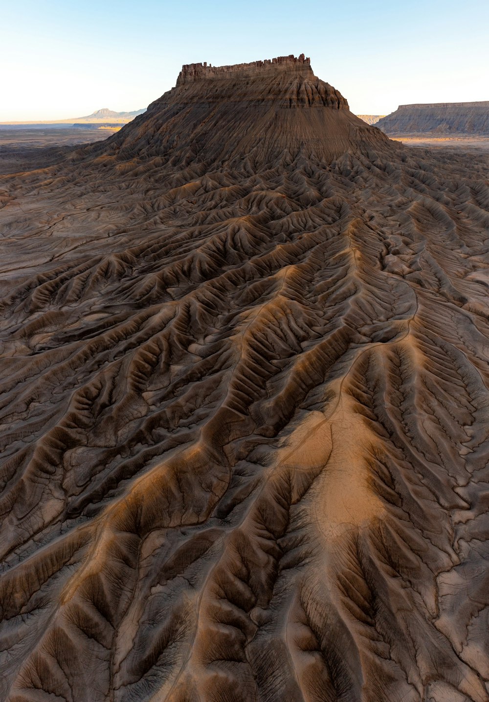 a very large hill with a very tall mountain in the background