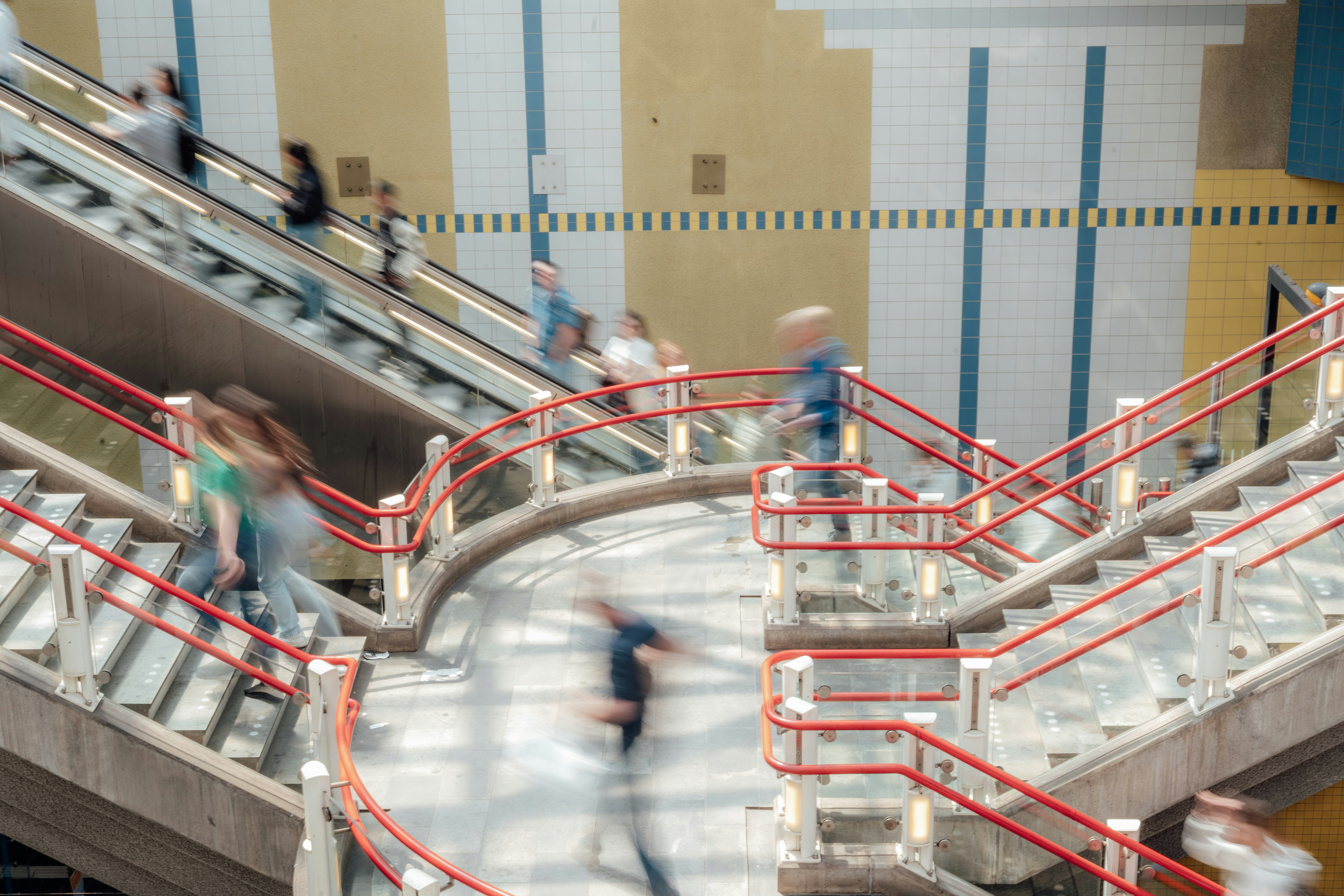 a group of people walking up and down an escalator