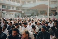 A group photo of Torah scholars engaged in lively discussion outdoors.