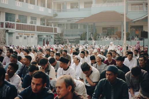 A serene community gathering organized by Mahadevi Dharmarth Trust, showing people engaged in a group discussion outdoors.
