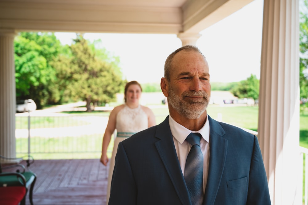 a man in a suit and tie standing next to a woman